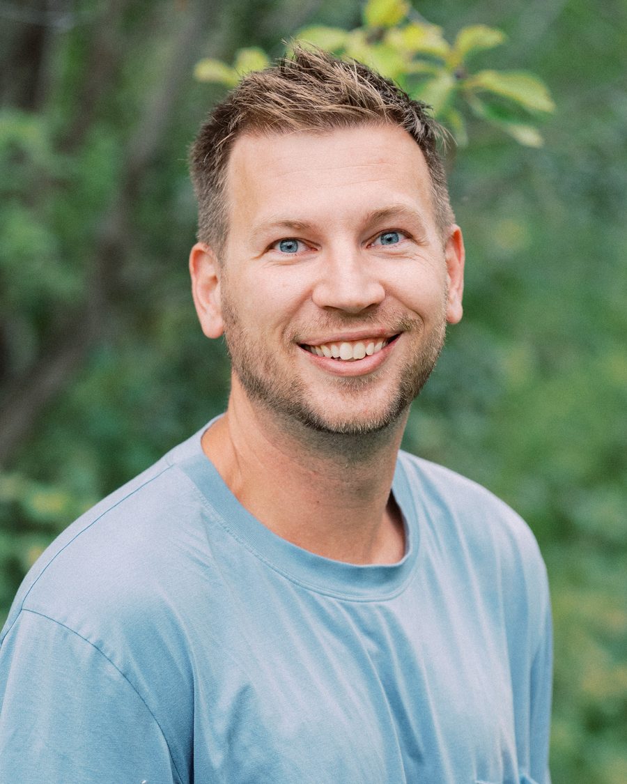 Tyler Golding, founder of Click Lift, smiling outdoors in a blue t-shirt